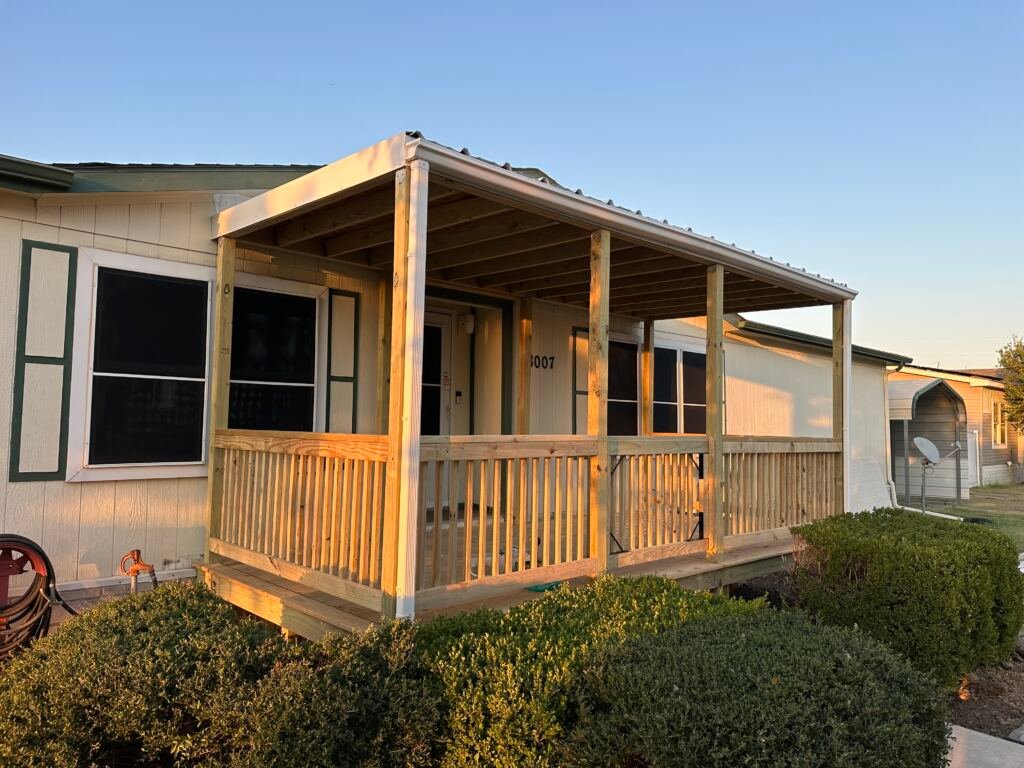 Nice front deck with a metal roof by Berglund Services