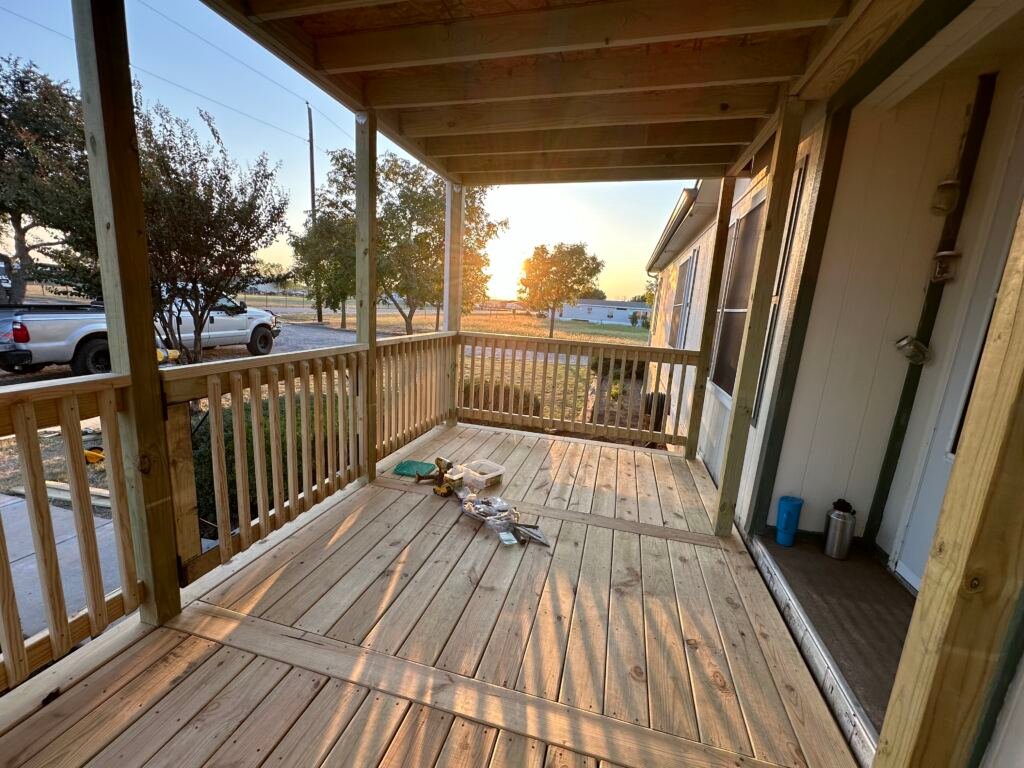 Nice front deck with a metal roof by Berglund Services