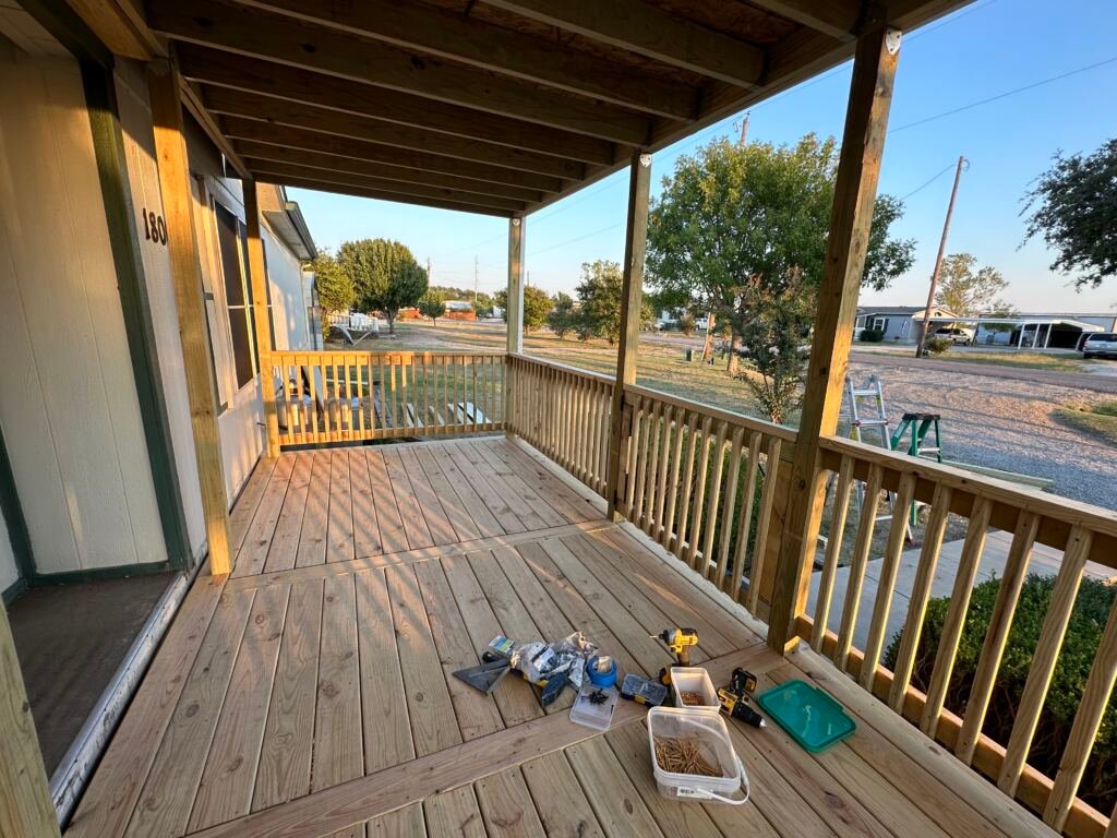 Nice front deck with a metal roof by Berglund Services