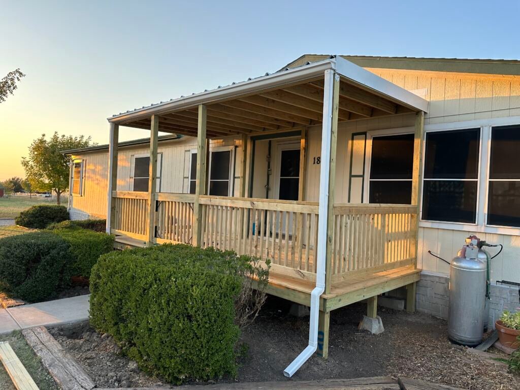 Nice front deck with a metal roof by Berglund Services