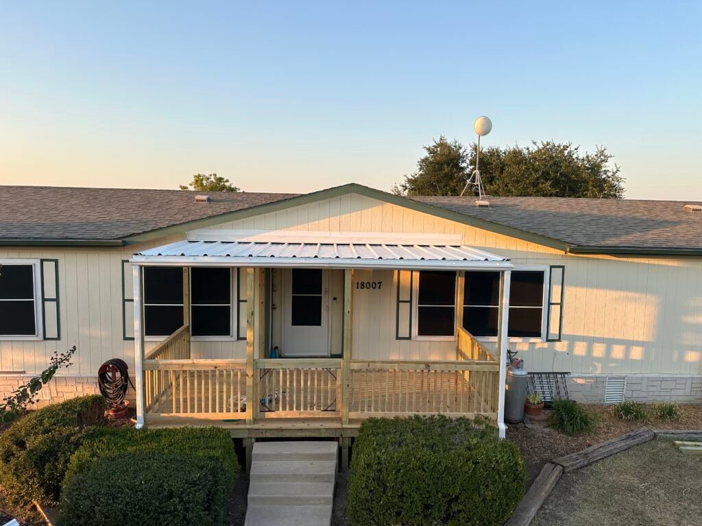 Nice front deck with a metal roof by Berglund Services